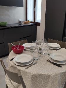 a table with plates and wine glasses on it at AL PONTE design apartment in Conegliano