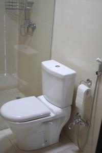- białą toaletę w łazience z prysznicem w obiekcie UkhutiEcoHouse w mieście Vani