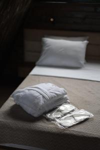 un cuscino avvolto in un foglio di stagno seduto su un letto di UkhutiEcoHouse a Vani