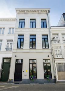 a white building with black windows at The 1880 Boutique Holiday Home in Antwerp