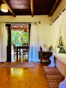 Un dormitorio con una cama y un comedor con una mesa. en Casa limão, en Trancoso