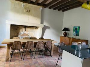 a dining room with a table and chairs and a fireplace at Maison de Campagne avec Piscine, Vallée de la Loire in Sarcé