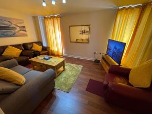ein Wohnzimmer mit 2 Sofas und einem TV in der Unterkunft Holiday Home In Cardiff. Sleeps 6 in Cardiff