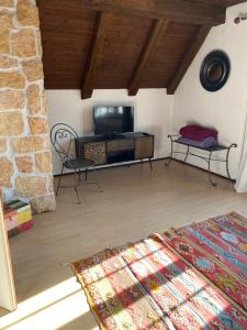 ein Wohnzimmer mit einem TV und einem Sofa in der Unterkunft La maison du petit bonheur in Moutier