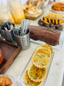 una mesa cubierta con platos de repostería y postres en Casa da Tuta Pousada en Tiradentes