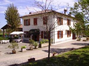 a large white house with a courtyard in front of it at Agriturismo La Cavaliera in Monteveglio