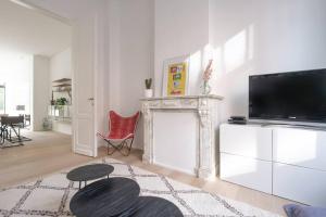 a living room with a fireplace and a flat screen tv at Spacious 1-bedroom duplex in Uccle! in Brussels
