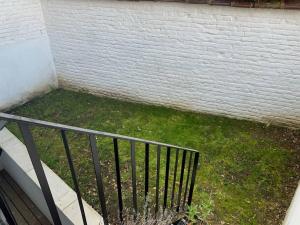 a balcony with a fence next to a brick wall at Spacious 1-bedroom duplex in Uccle! in Brussels