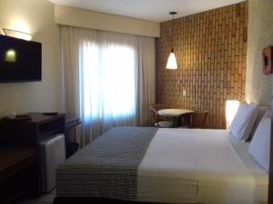 a hotel room with a large bed and a window at Rifoles Praia Hotel e Resort in Natal