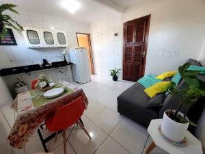 a kitchen and a living room with a couch and a table at Teto Hospedagens Va in Fortaleza