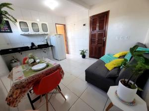a kitchen and a living room with a couch and a table at Teto Hospedagens in Fortaleza