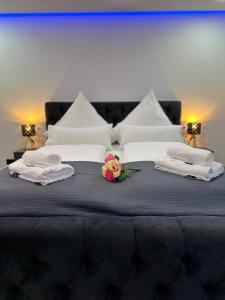 un grande letto con asciugamani e fiori di Modern Apartments Neuburg 3 - TOP NEU - 2 Zimmer, Komfort, Balkon, Wi-Fi, Smart TV, Badewanne, Küche a Neuburg an der Donau