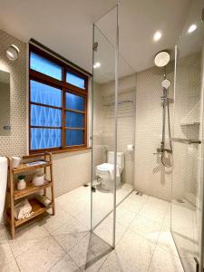 a bathroom with a glass shower and a toilet at Humanlive in Tainan