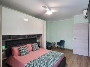 - une chambre avec un lit rose et une armoire blanche dans l'établissement Casa Lariana, à Lecco