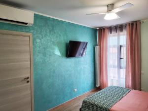a bedroom with a bed and a tv on the wall at Casa Lariana in Lecco