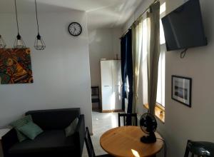 a living room with a table and a couch and a clock at Apartament Kętrzyński in Kętrzyn
