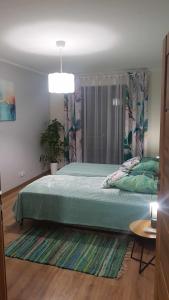 een slaapkamer met een groot groen bed in een kamer bij Domek dwupoziomowy pod Brzozami 4P in Chrzanów