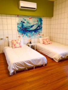 duas camas num quarto com um quadro na parede em Liuqiu Cozy Room em Xiaoliuqiu