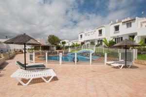 basen ze zjeżdżalnią oraz 2 krzesłami i parasolami w obiekcie Casa Maravilla Golf del Sur w San Miguel de Abona