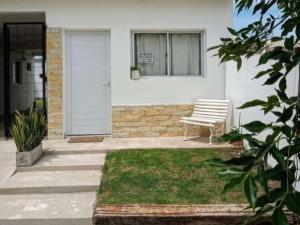 un banco blanco sentado frente a una casa en Monoambientes Arandu en Federación