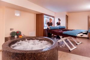 two women standing in a room with a bath tub at Gomersal Park Hotel & Dream Spa in Cleckheaton