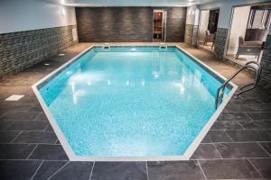 a large pool with blue water in a building at Gomersal Park Hotel & Dream Spa in Cleckheaton