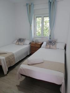 1 dormitorio con 2 camas y ventana en Villa Mayki, 