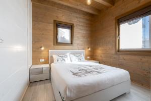 Un dormitorio con una cama en una pared de madera. en Ivan House, en Livigno