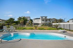 een zwembad in een tuin met een huis bij Long Call by Oak Island Accommodations in Oak Island