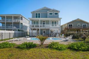 een groot huis met een zwembad ervoor bij Long Call by Oak Island Accommodations in Oak Island