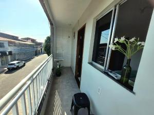 a balcony with a vase with flowers in a window at Teto Hospedagens Va in Fortaleza