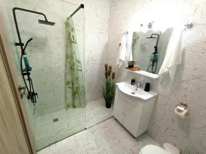 bagno bianco con lavandino e doccia di Summer Haven- self check-in, parking, netflix, terrace, near mall a Oradea