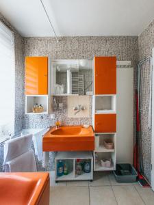 łazienka z pomarańczowymi szafkami i umywalką w obiekcie Apartman Stadion w mieście Osijek