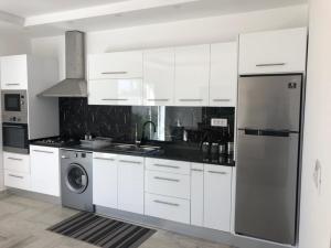 a kitchen with white cabinets and a stainless steel refrigerator at Villa Lucia in Djerba