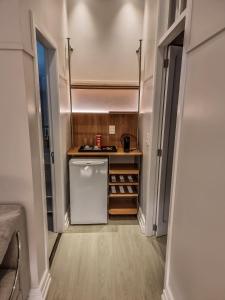 a small kitchen with a refrigerator in a room at Mosteiro Hotel de Charme próximo ao Vale dos Vinhedos in Garibaldi