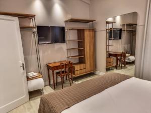 um quarto de hotel com uma cama, uma mesa e cadeiras em Mosteiro Hotel de Charme próximo ao Vale dos Vinhedos em Garibaldi