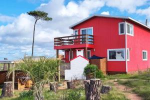 a red house with a red roof at Klimatisiertes Haus am Meer in Chihuahua in Punta del Este