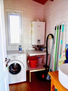 a small kitchen with a washing machine and a window at Klimatisiertes Haus am Meer in Chihuahua in Punta del Este