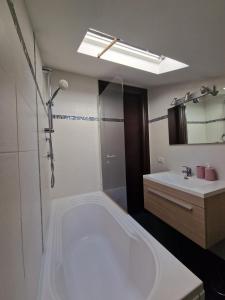 baño con bañera blanca grande y lavamanos en CASA.AD en Bracciano