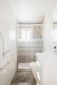 a white bathroom with a toilet and a shower at Habitaciónes bonitas y cómodas in Hospitalet de Llobregat