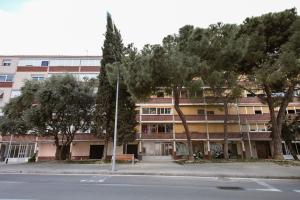an apartment building with trees in front of a street at Habitaciónes bonitas y cómodas in Hospitalet de Llobregat