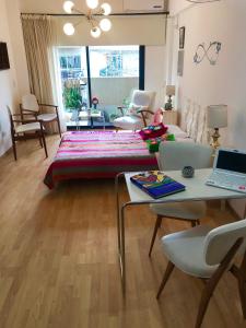 a living room with a bed and a table with a laptop at Studio Plaza con sillón cama in Buenos Aires