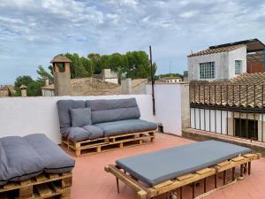 a patio with couches and tables on a roof at Can Joan Empordà in Ordis