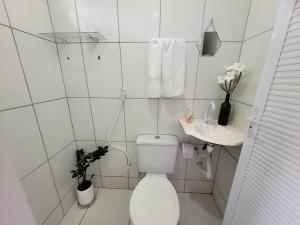 a white bathroom with a toilet and a sink at Teto Hospedagens Va in Fortaleza +18 photos