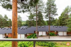 a house with a black roof in the woods at APt 37 in Rovaniemi