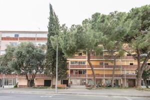 a building with trees in front of a street at Habitaciónes bonitas y cómodas in Hospitalet de Llobregat
