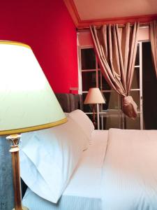 a bedroom with red walls and a bed with a lamp at DUO BOUTIQUE HOTEL in Medellín