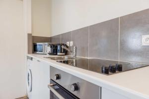 a kitchen with a sink and a microwave at Nice apartment 4P- Levallois Anatole France in Levallois-Perret