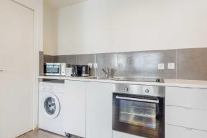 a kitchen with a washer and a sink and a stove at Nice apartment 4P- Levallois Anatole France in Levallois-Perret