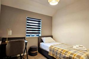 1 dormitorio con cama, escritorio y ventana en Luxury 3-Bed House in the Scottish Highlands en Inverness